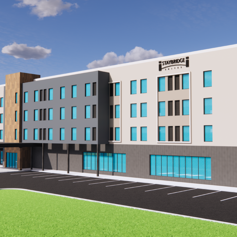 A rendering of the Staybridge Suites hotel planned for Kincardine, Ontario. The building is 4 stories high, modern exterior with wood tones and dark grey with light beige, many windows on the ground floor and exterior ground level parking.